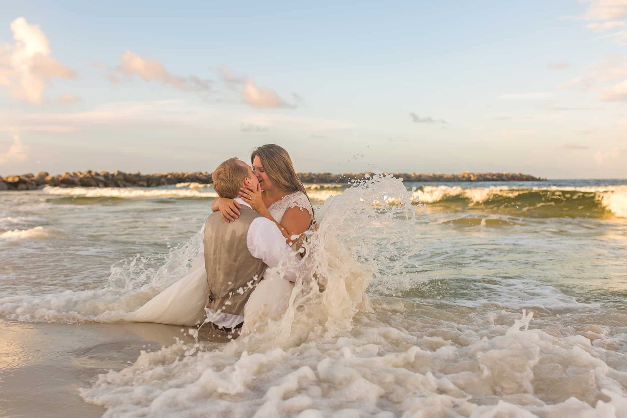Romantic image of husband and wife, kissing in the surf.