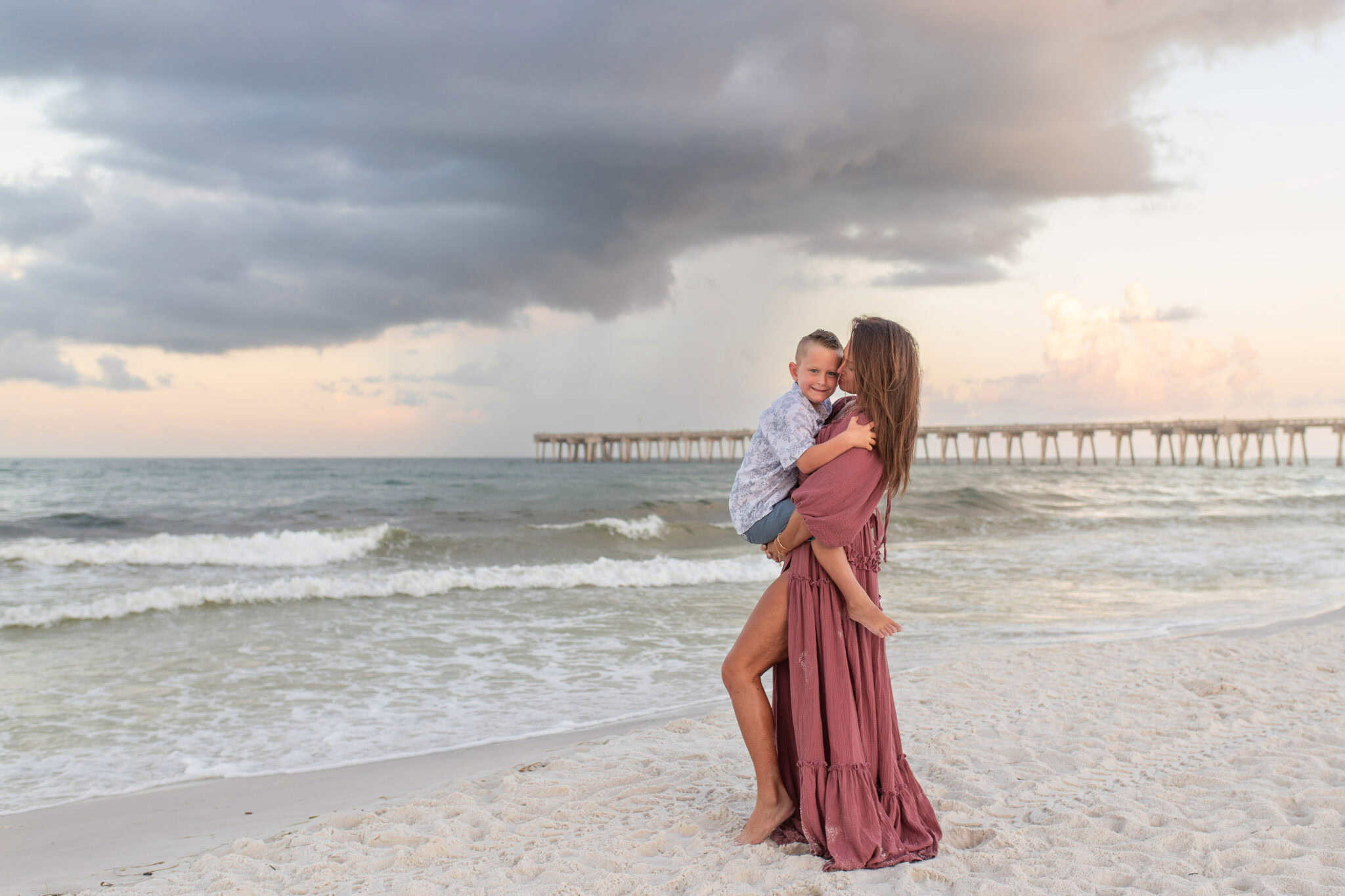 BG0I4291-2048×1365 Mother holding child at the beach with PCB pier in the background
