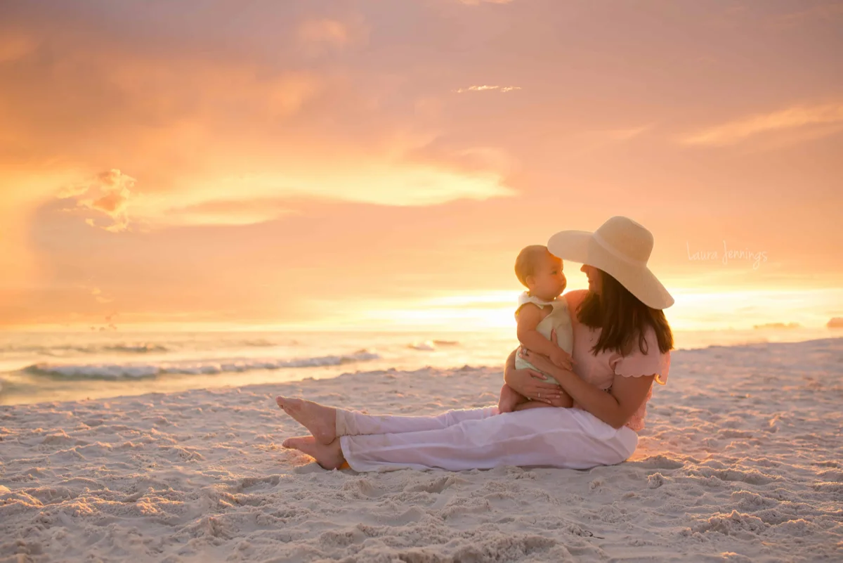 Mother and child sitting on the beach in the sunset