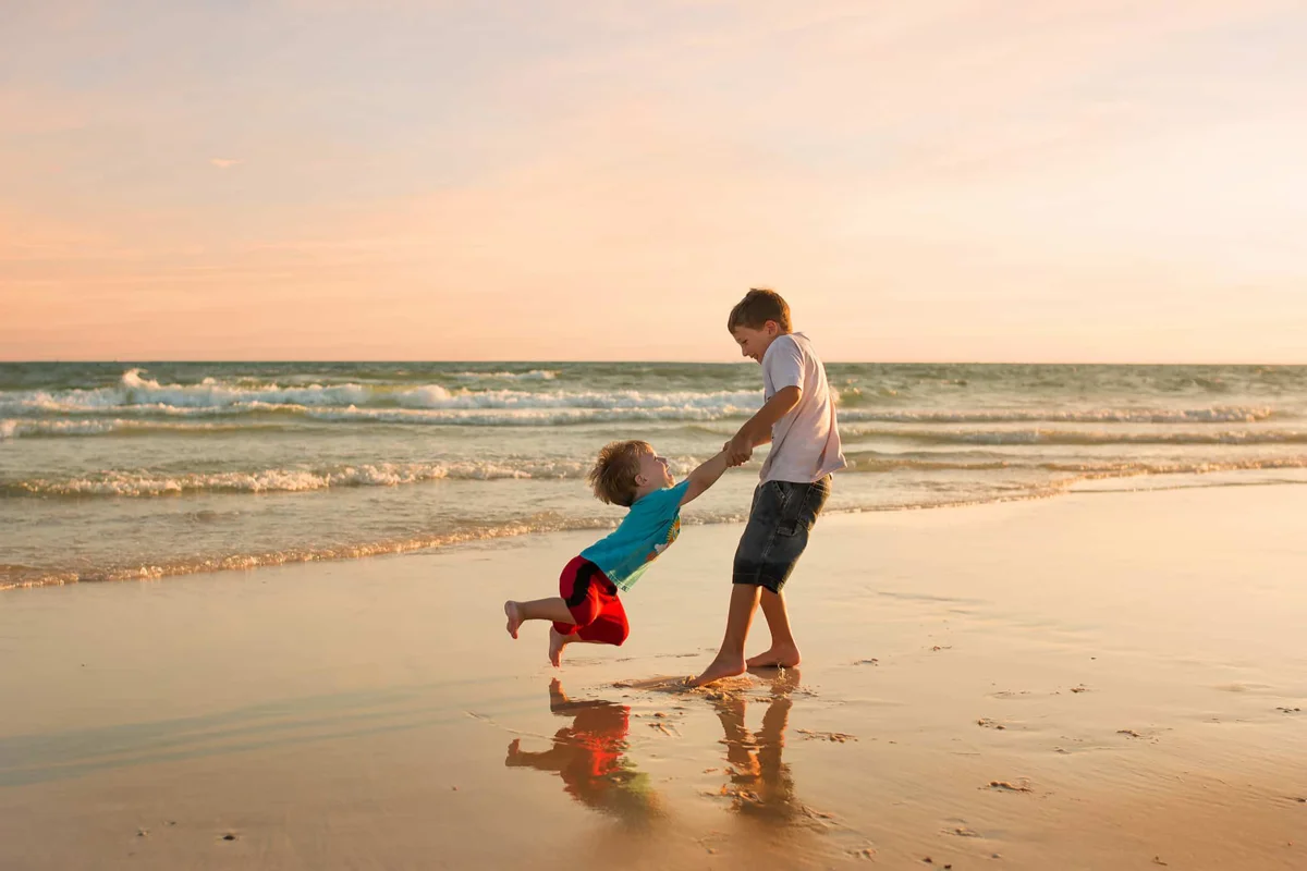 Two brothers playing together on the beach
