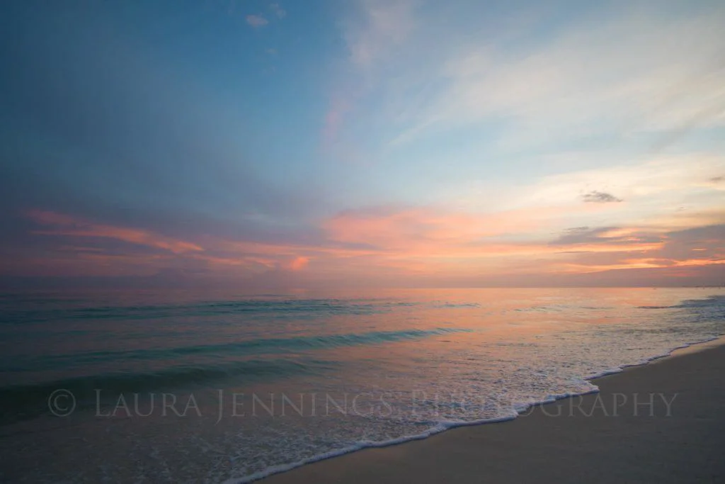 A beach with a storm at sunset