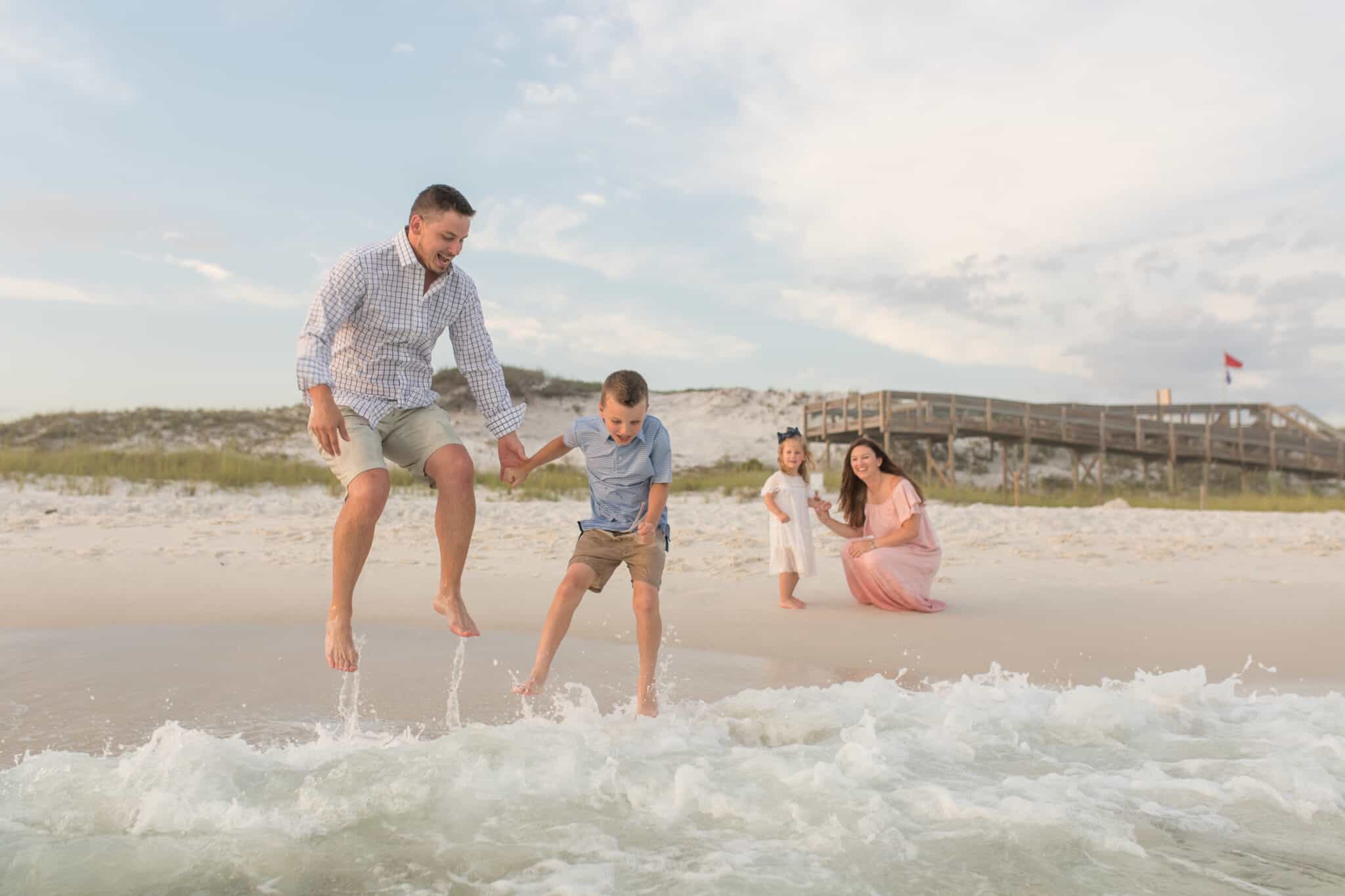 A dad and son wave jumping on a Sth Walton County beach